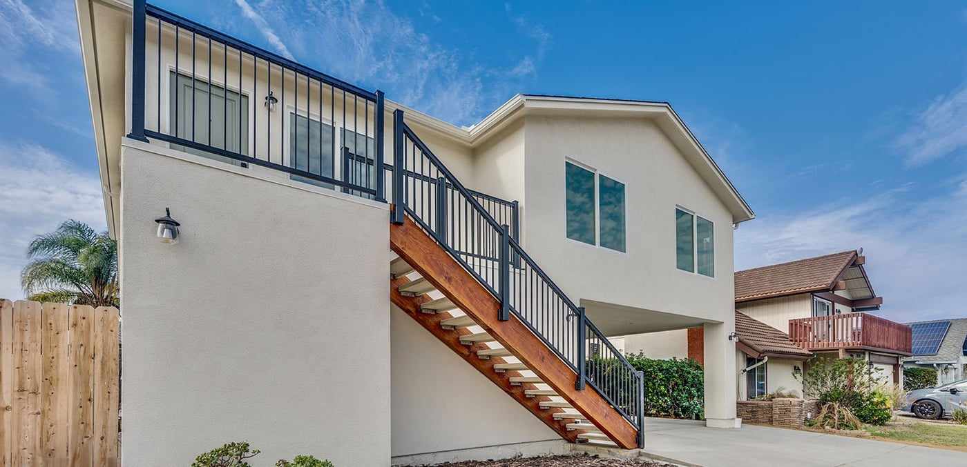 Exterior wood staircase with black railings up to the attached ADU above a Mira Mesa garage