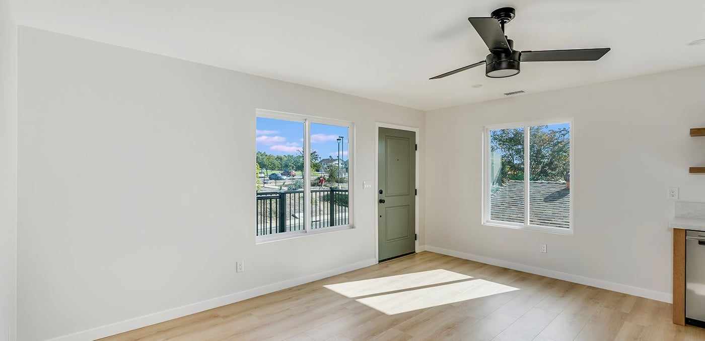 ADU living room, empty, with a ceiling fan and two windows