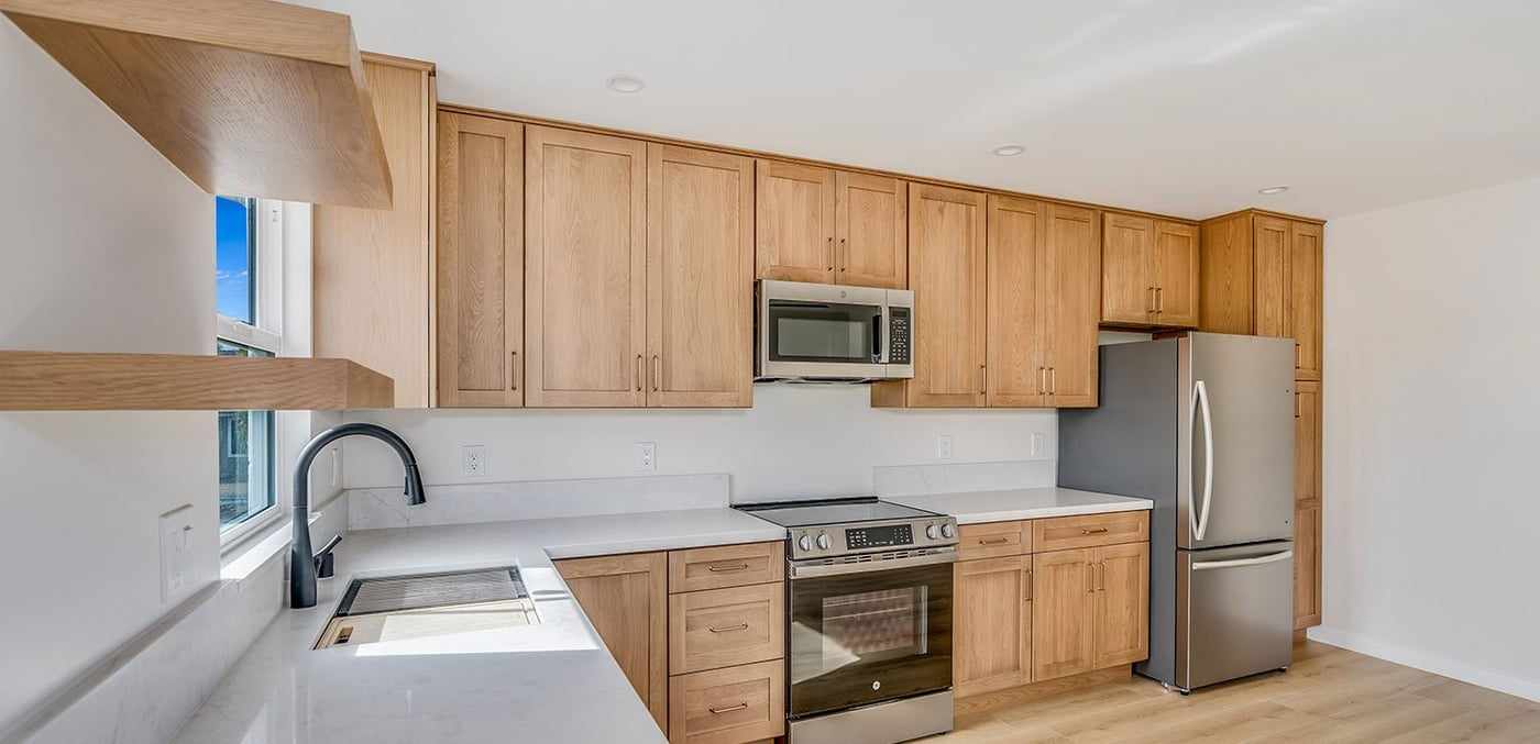 ADU kitchen with floating shelves, a range and a refrigerator
