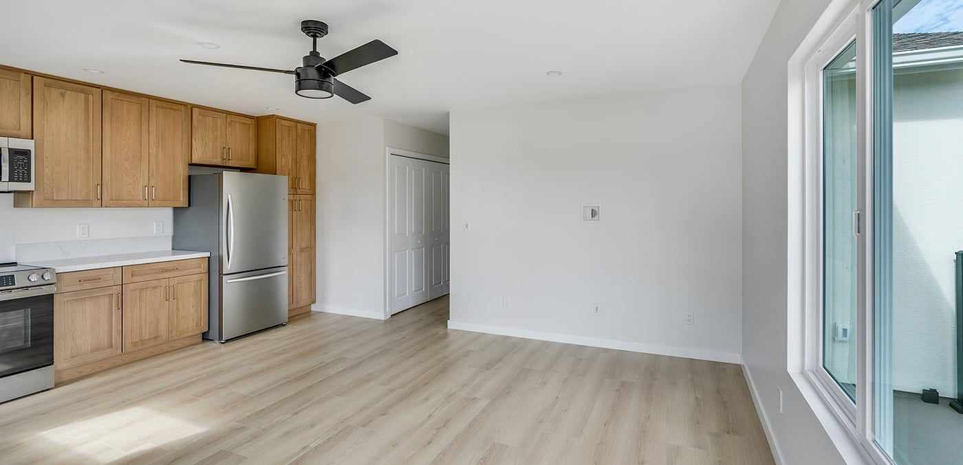 ADU living area with the kitchen at one end and a glass door to the deck