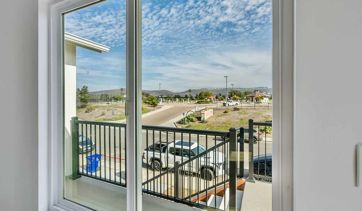 View through the attached ADU glass door to the deck railing and the Mira Mesa neighborhood