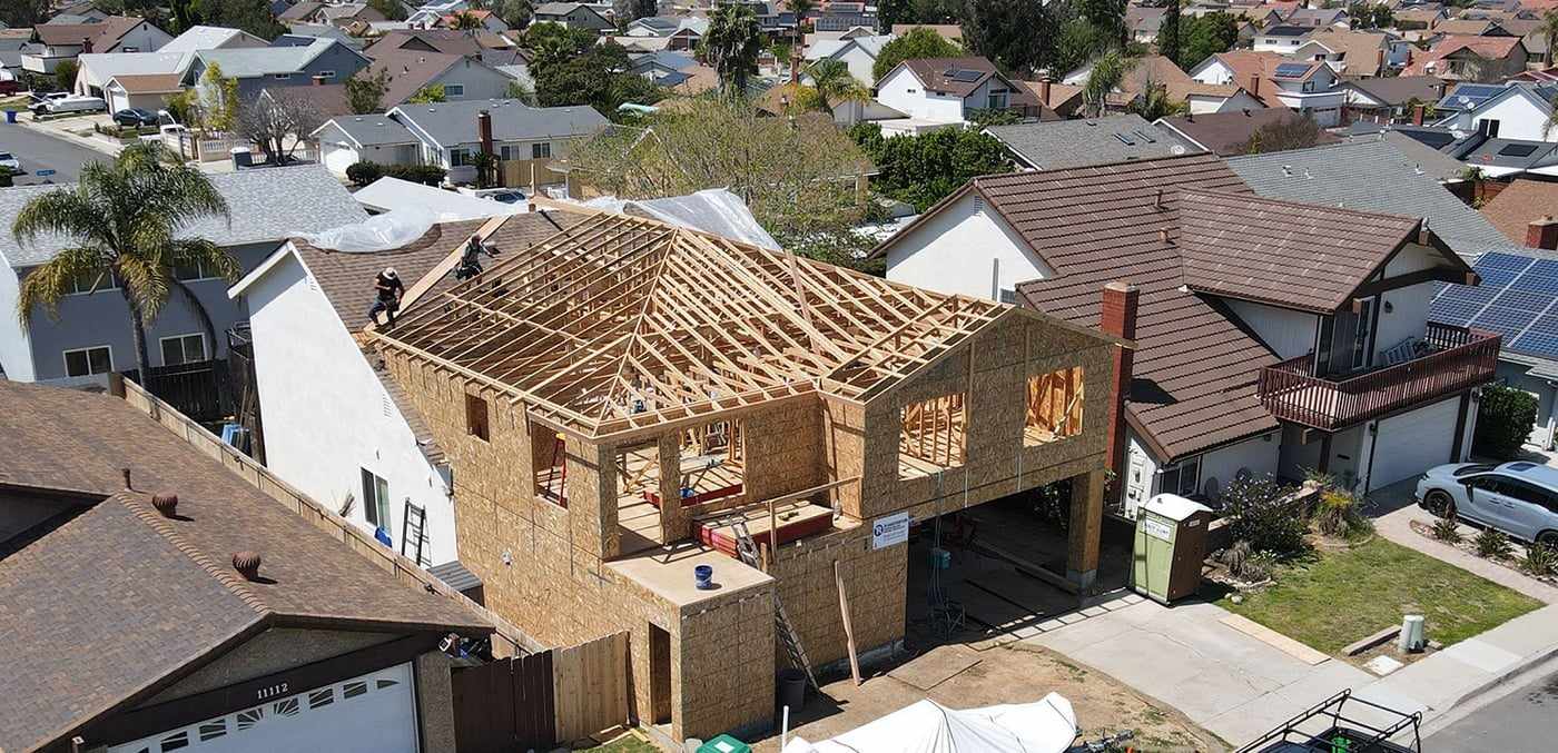 Aerial view of the framed attached ADU above the garage among neighboring Mira Mesa homes
