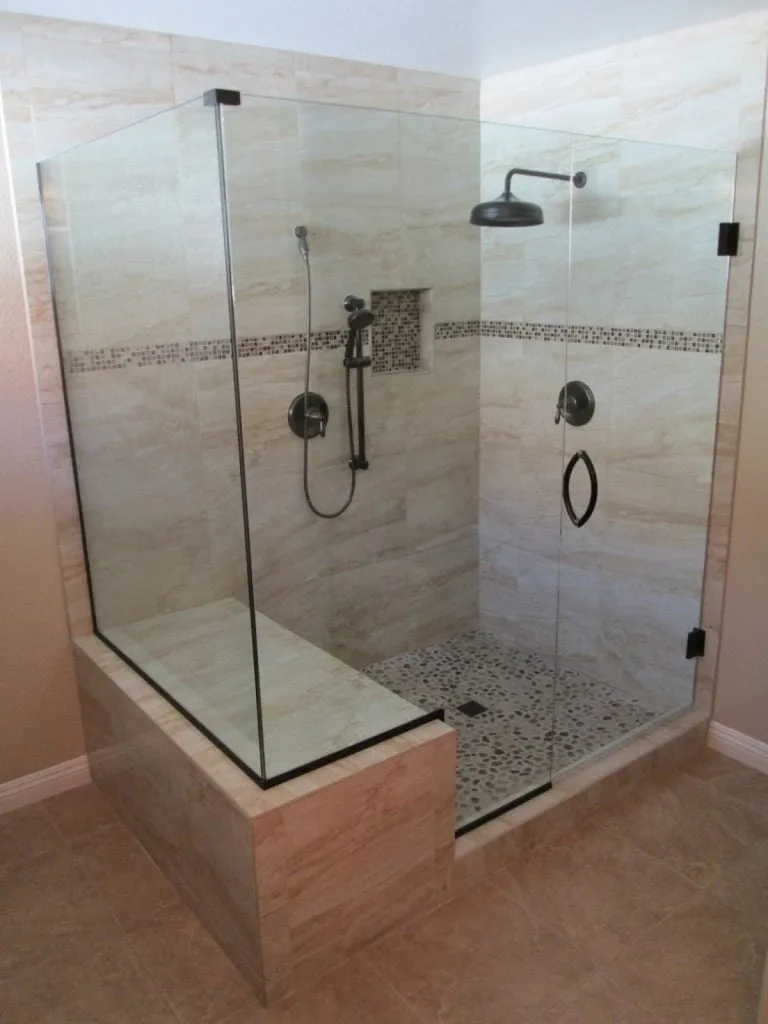 Walk-in glass shower with a tiled bench