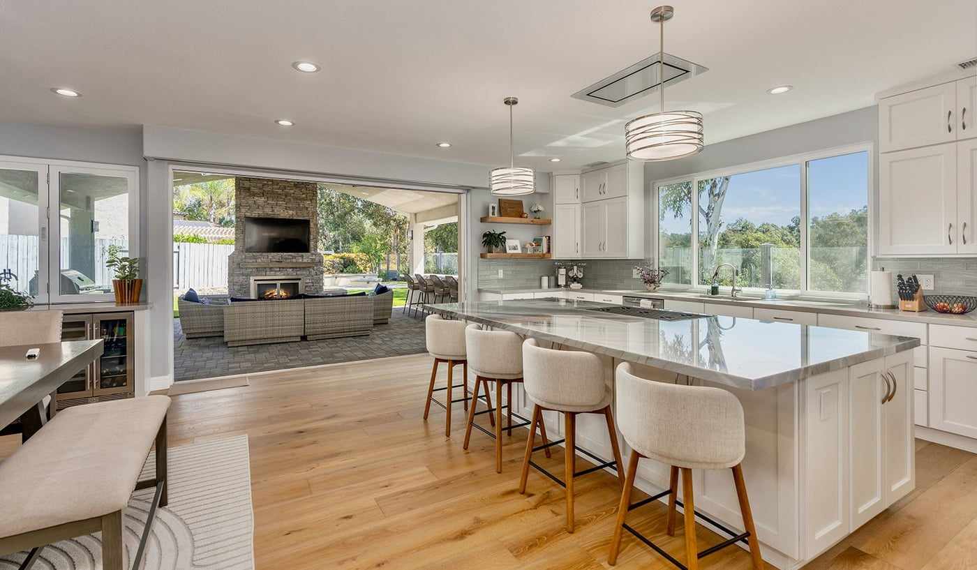 Kitchen and family room opening onto a covered patio through folding glass doors