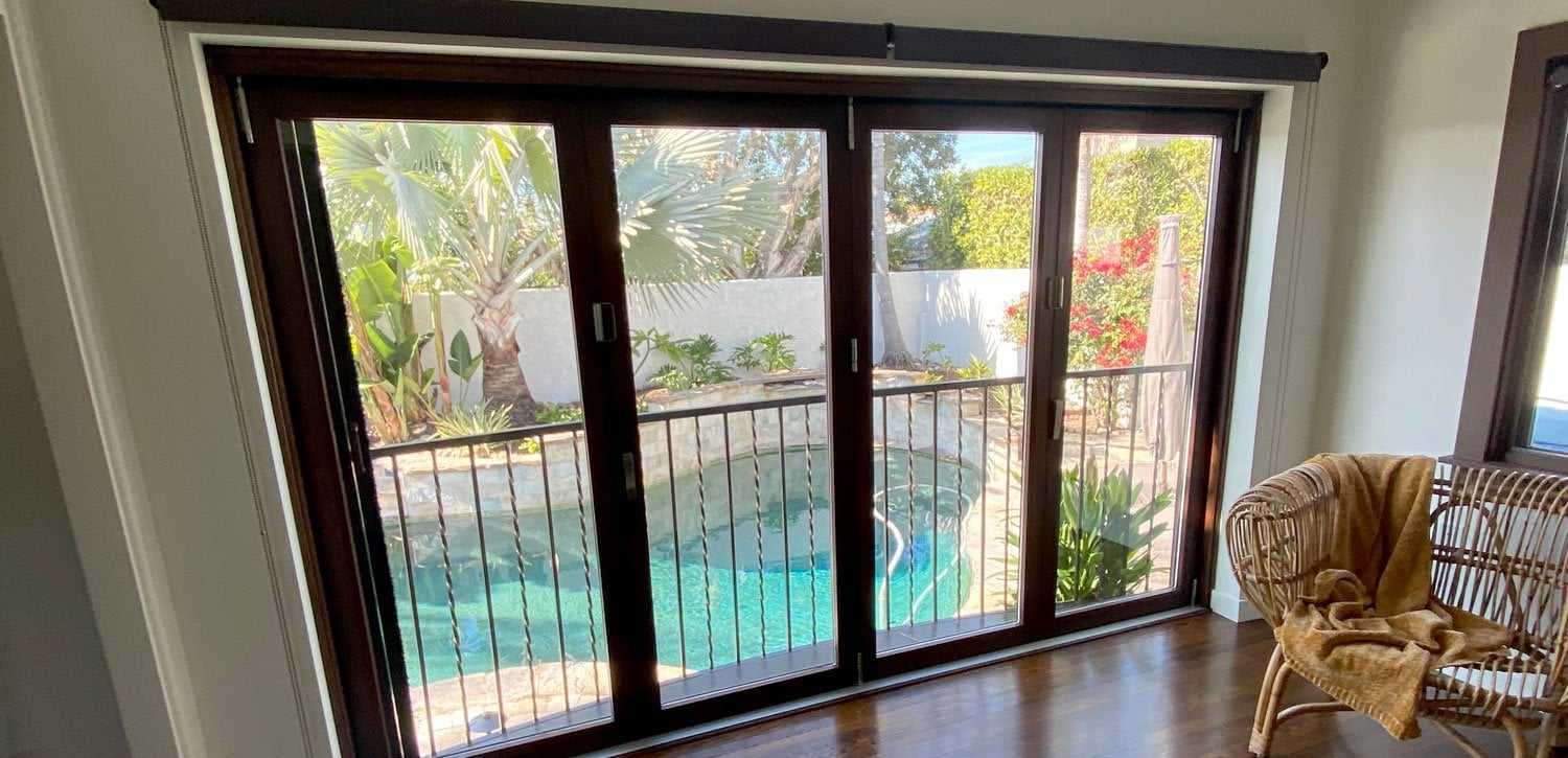 New folding glass patio doors opening onto a backyard pool