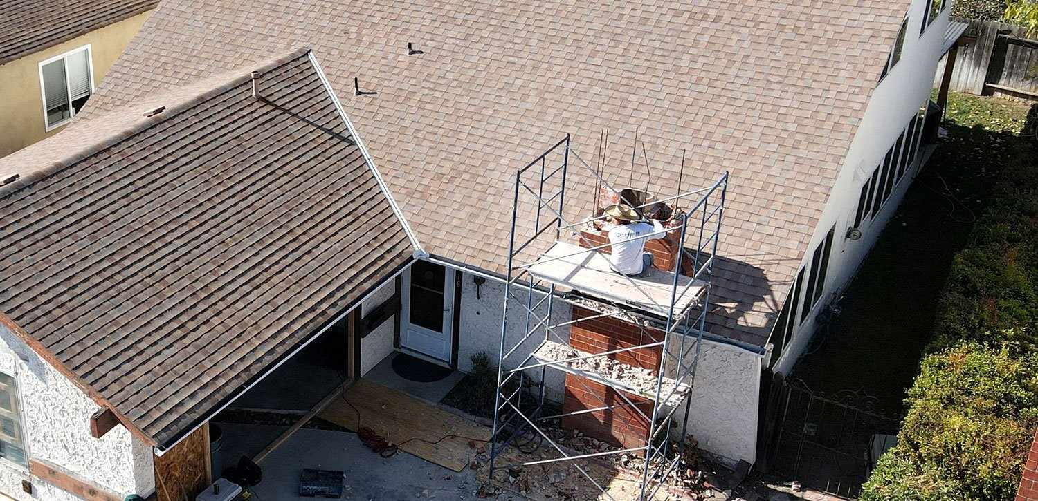 TR Construction crew member on scaffolding taking down a brick chimney