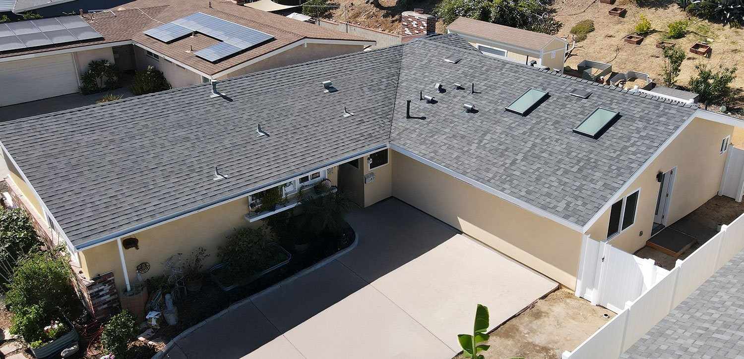 Aerial view of a home with a new gray shingle roof and skylights after a garage conversion ADU