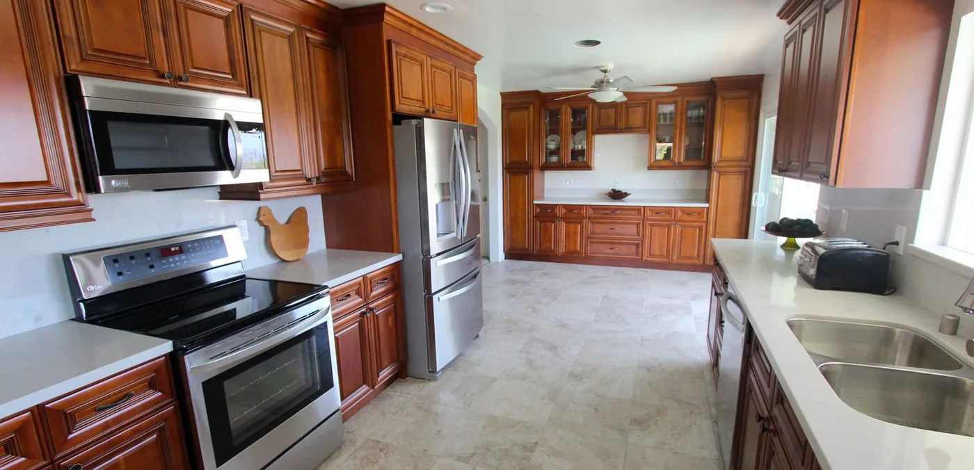 Kitchen with cherry cabinets, white counters and stainless steel appliances