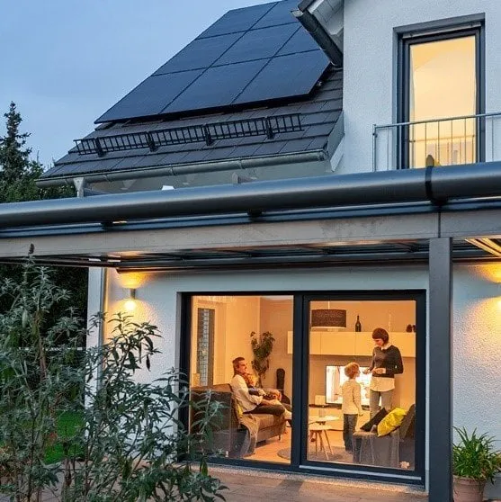 Black solar panels on a house at dusk